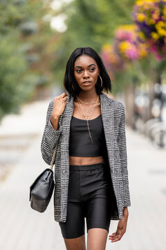 Beautiful stylish young woman on city sidewalk