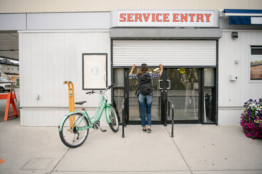 Female business owner opening bike shop service entry gate
