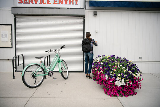 Female shop owner unlocking bike shop service entry gate