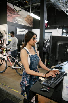 Female business owner working at computer in bike shop