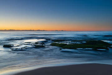 Naklejka premium Clear skies and soft seas, dawn at the beach