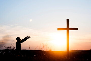 Prayer. Repentance. A man near the cross. He worships God with raised hands in prayer. - obrazy, fototapety, plakaty