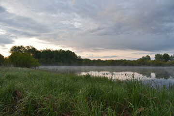 colorful and misty dawn over a small river