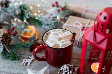Winter hot drink, cacao with marshmallows and cinnamon or spicy hot chocolate in red cup. Merry Christmas. Festive vintage background
