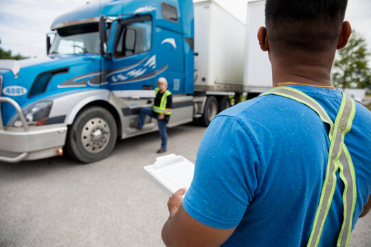Trucker looking at paperwork for container semi truck