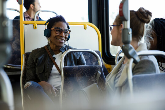 Happy Female Passengers Talking On Public Bus