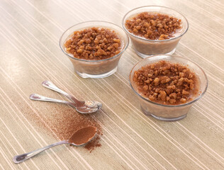 Three bowls with ashure, a typical Albanian dessert with wheat, dried fruit and cinnamon. Spoons.