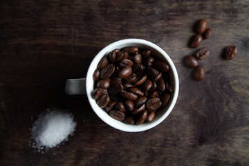 Cup of espresso beans and sugar on wood
