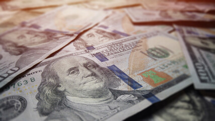 Hundred dollar benjamin franklin bills in pile for business and financial concept.  American US dollar federal reserve background texture.  Prosperity for economic impact and financial abundance.