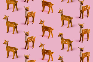 Christmas layout pattern made with reindeer toy on the bright pink background. Minimal New Year or winter season concept. Greeting card or banner.