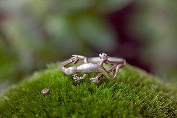 Sterling silver ring in the shape of lizzard on green moss background