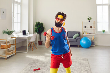 Bearded funny man in bright sport clothes doing workout with dumbbels at home