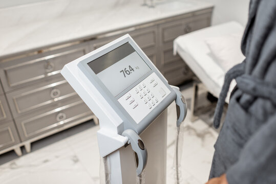 Woman measuring body composition balance, holding handles of a medical scales during Inbody test