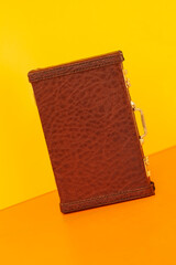Vintage brown diplomatic briefcase with texture reptile, crocodile on bright yellow orange...