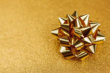 Gold gift bow on a gold background. Holidays.
