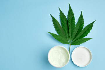 Leaf of cannabis and plastic package or jar with copy space with cream contained hemp oil