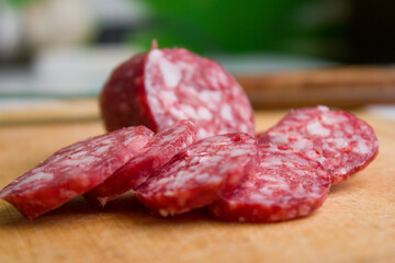 Sliced Appetizing smoked sausage on wooden background