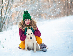 Image of young girl with her dog white golden retriever hugging, outdoor at winter time. Domestic pet. woman playing with dog. Closeup portrait