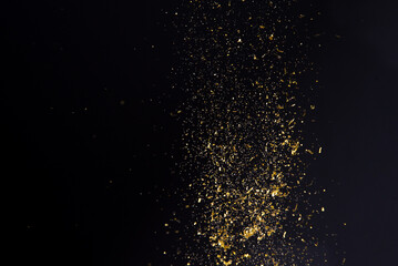 Fototapeta na wymiar abstract background floating gold glitter on black background