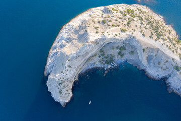 White rock in the middle of the sea with turquoise water color. Shooting from the air.