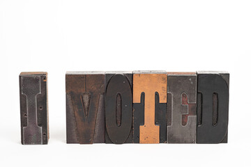 Wood block type isolated on a white background spelling out I voted