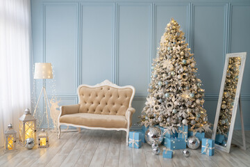 Stylish Christmas interior decorated in blue colors. Comfort home. Sofa, gifx boxes, mirror balls, garland, candle lamp.