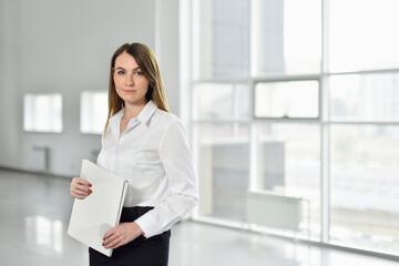 Portrait of a entrepreneur woman with documents in her hands on the background of an empty office for new business
