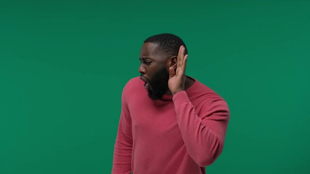curious interested delightful funny amazed african man holding hand near ear and trying to hear the information on Green Screen, Chroma Key