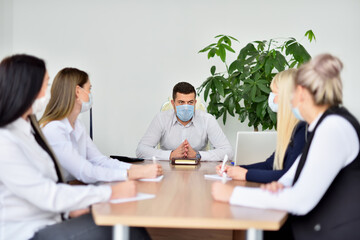 Business meeting of employees and CEO wearing face masks