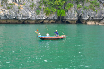 Two fishermen in a boat. Halong Bay.