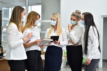 Female office managers wearing face masks at a meeting in the office