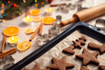 Baking sheet with brown chocolate shortbread in stars and heart shapes. Winter decor, baking objects on the background; christmas atmosphere.