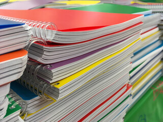 School supplies, lots of notebooks with spiral are on sale at the supermarket. Parents will buy notebooks for their kids before the schools get opened. Education time for the students.