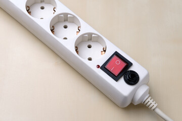 A rosette with a red button lies on the left corner.