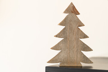 A wooden Christmas tree decoration on the corner of a shelf.  - 388863268