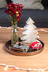 a coffee table is decorated with Christmas accents such as a wooden Christmas tree and red camping trailer ornament.  - 388863628