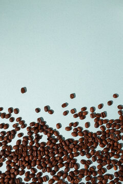 brown coffee beans on blue background, copy space.