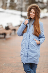 young woman are walking in the winter park. Winter park in the snow. Clothing advertising photo concept