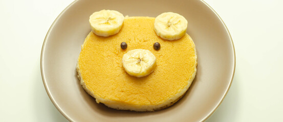 Creative meal for a child, pancake with banana and chocolate  in a face little bear  shape