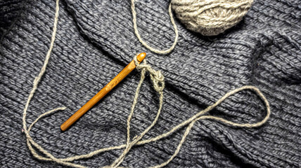 Photo of a crochet hook, wool yarn queens, knitting. Gray color scheme. Background for  content. Crochet. Hobby. Flatley.
