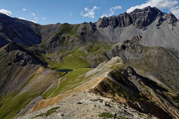 Alps mountains landscape view with little lake (Lac de Souliers). Girl tourist with hat and camera...
