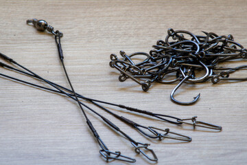 Black fishing hooks lined up to form a path at the beginning, dispersed and at the bottom more complex and compact. Hooks used for fishing of several species, including tilapia and catfish.