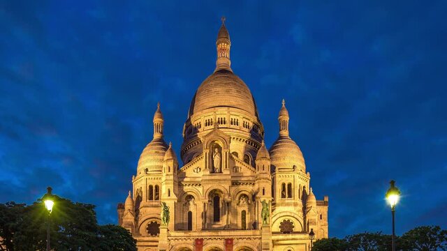 Frontal view of Sacre coeur (Sacred Heart cathedral) day to night transition timelapse. People sitting on stairs. Paris, France