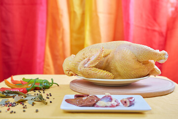 Raw chicken on a yellow background. © Malsveta