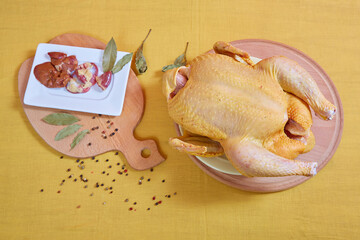 Raw chicken on a yellow background. © Malsveta