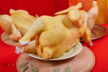 Three raw chicken on red background.