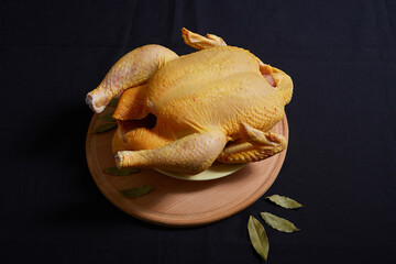 Raw chicken on black background. © Malsveta