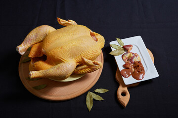 Raw chicken on black background. © Malsveta