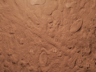 Dirty brown background. Dusty surface and footprints.