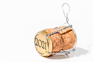 Close-up of a champagne cork with its cage on a white background. Cork has a date of 2021